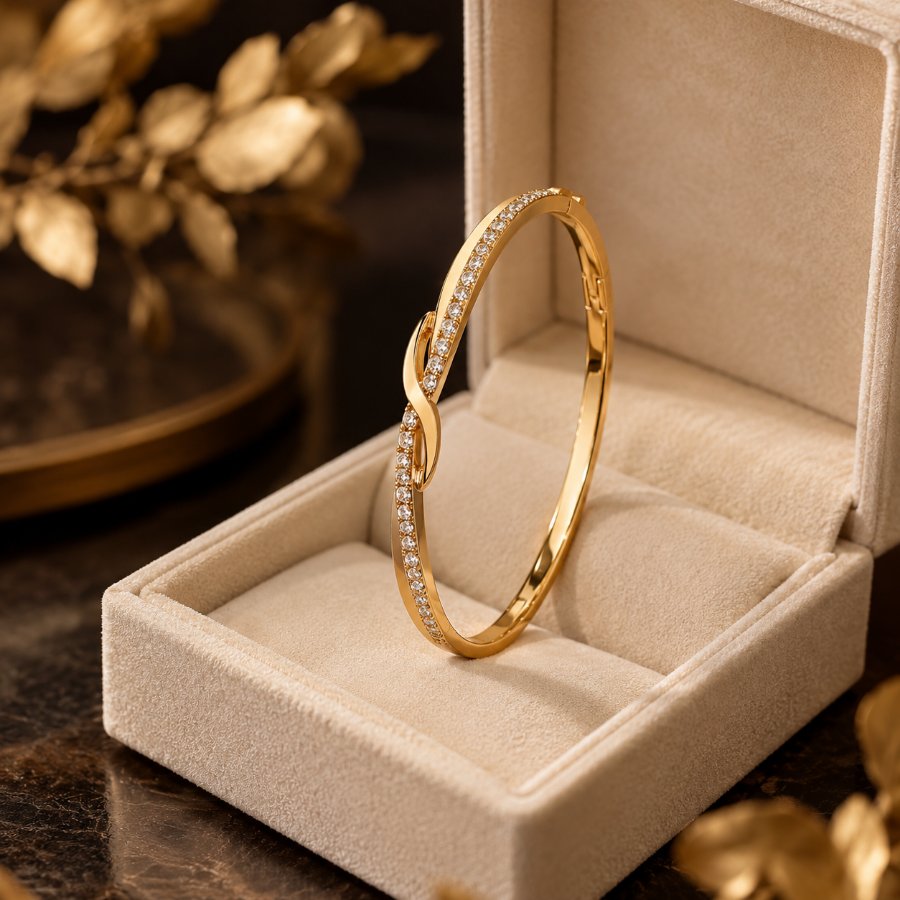 Gold crystal-set bangle in an open cream jewellery box